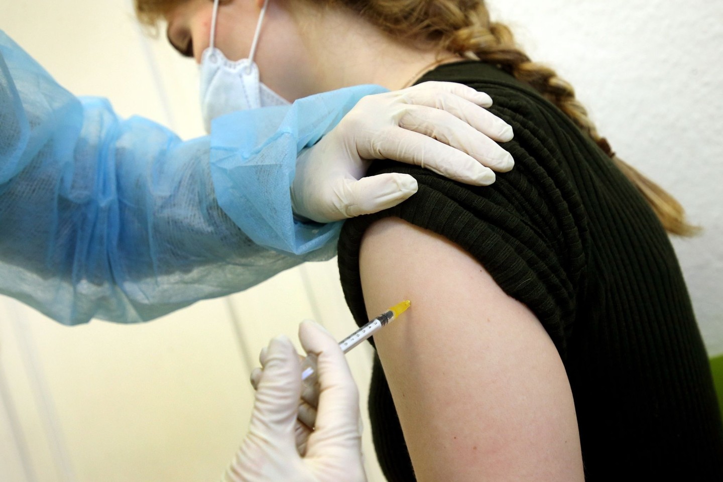Eine junge Frau bekommt in der Praxis ihrer Hausärztin ihre Booster-Impfung.