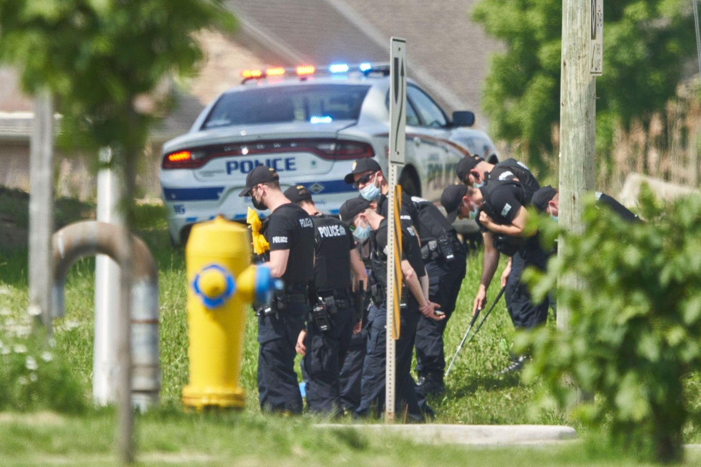 Polizisten in Reihe untersuchen den Tatort eines Autounfalls in London, Ontario. Nach einem Angriff mit einem Auto, bei dem vier Menschen aus einer muslimischen Familie getötet worden sind,...
