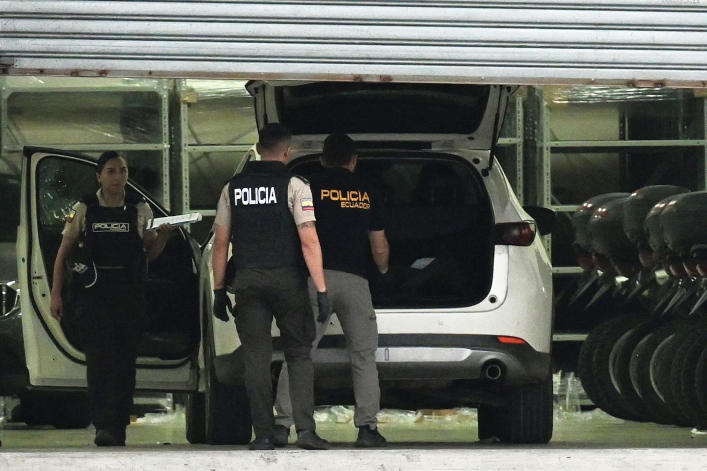 Polizisten in Schutzwesten untersuchen das Auto des erschossenen Staatsanwalts César Suárez.