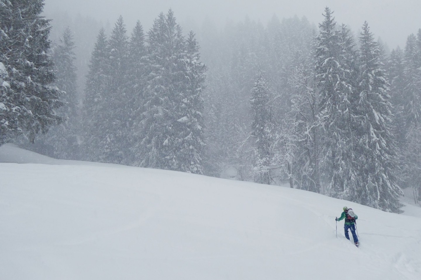 Ein Skitourengeher steigt durch viel Neuschnee einen Berg bei Garmisch-Partenkirchen hinauf.
