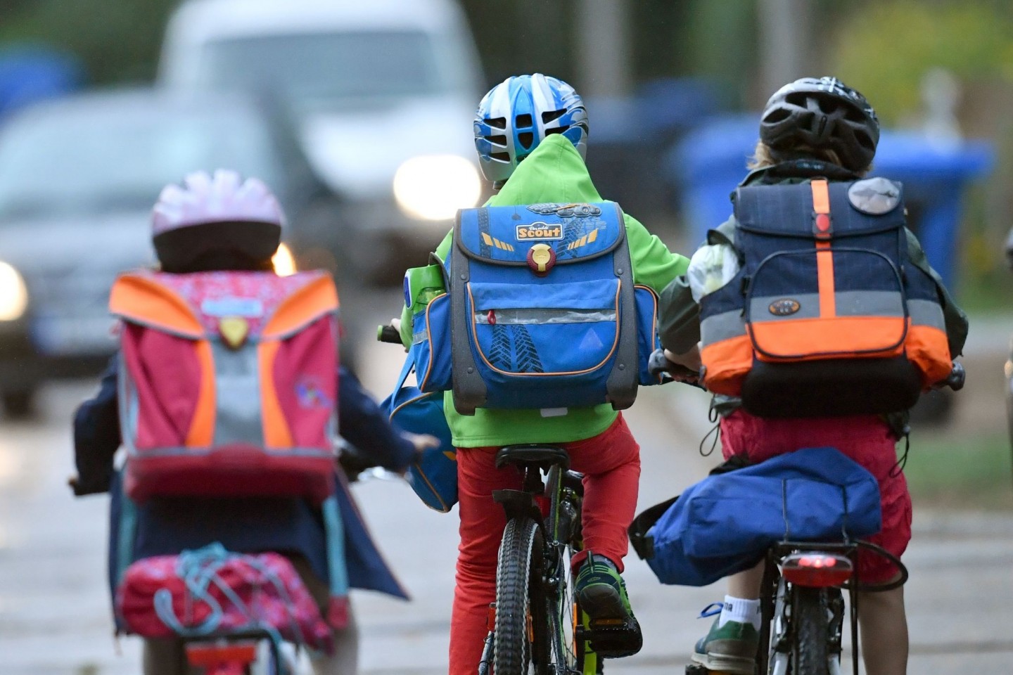 Kinder sind auf einer Straße mit dem Fahrrad unterwegs zur Schule. Symbolbild