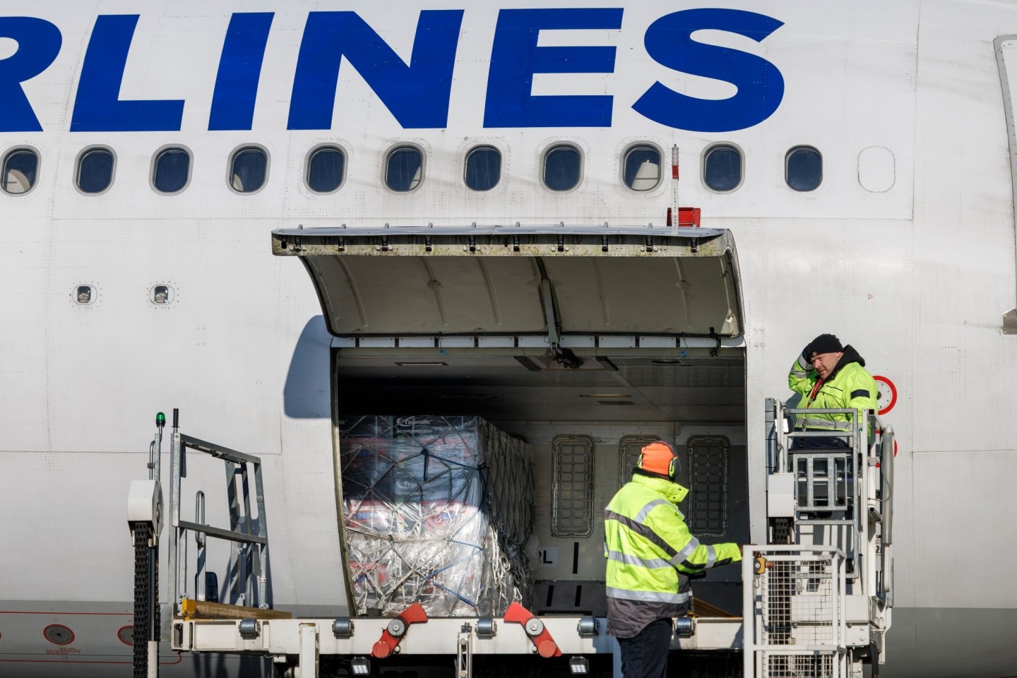 Flughafenmitarbeiter laden auf dem BER-Rollfeld Paletten mit Hilfsgütern für die Türkei in ein Flugzeug der türkischen Fluggesellschaft Türkish Airlines.