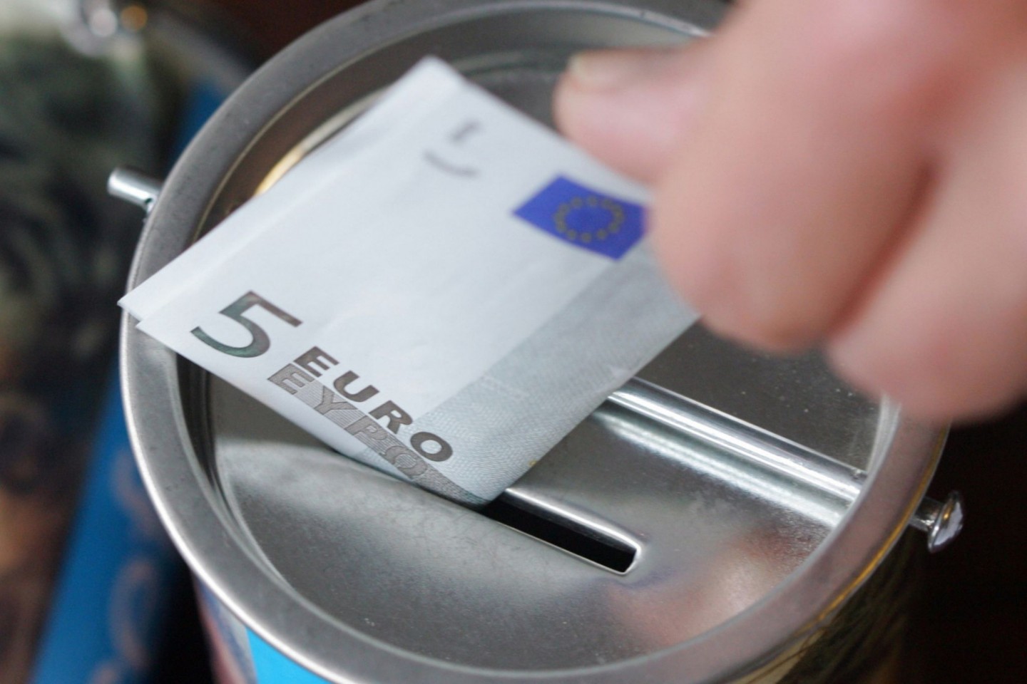 Ein Fünf-Euro-Schein wird in eine Spendendose gesteckt. Symbolbild