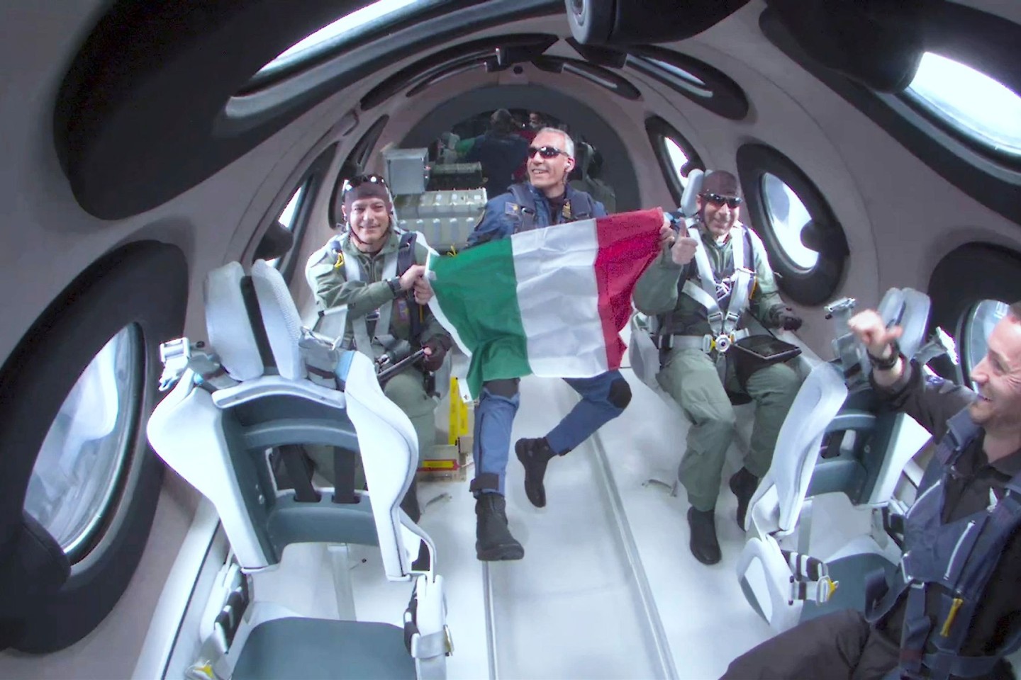Walter Villadei (M), Wissenschaftler der italienischen Luftwaffe, hält eine italienische Fahne, während er und andere italienische Forscher einige Momente der Schwerelosigkeit an Bord des ...