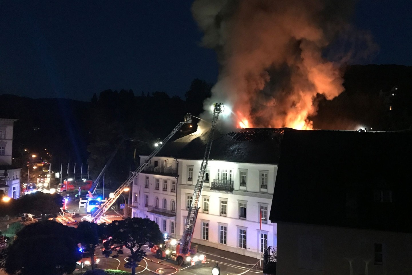 Die Feuerwehr löscht von Drehleitern aus das Hotel «Badischer Hof» (2021). Etwa 160 Gäste mussten vor dem Feuer in Sicherheit gebracht werden.