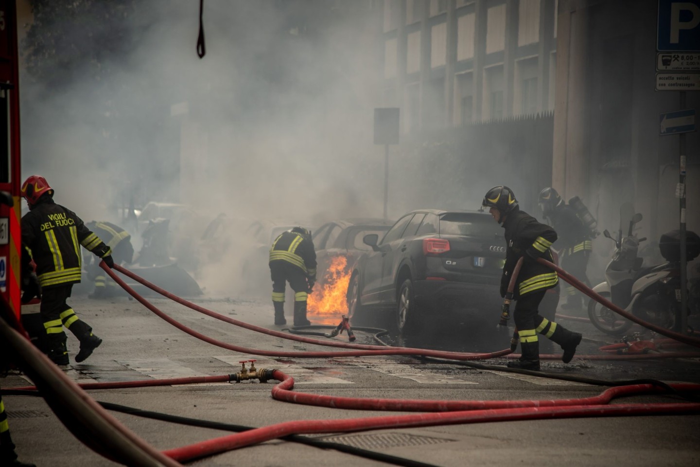 Feuerwehrleute löschen mitten in Mailand brennende Fahrzeuge.