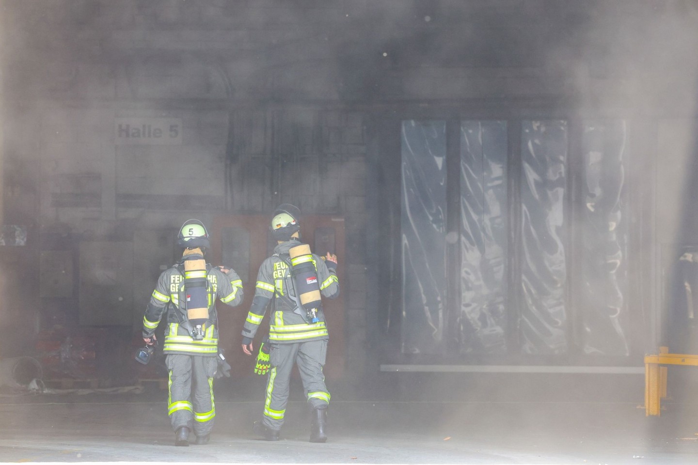 Kräfte der Feuerwehr verschaffen sich nach der Explosion in einer Industriehalle einen Überblick.