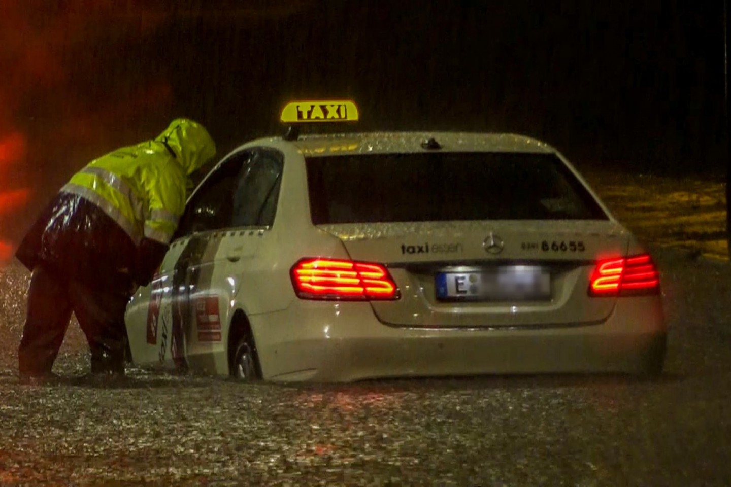 In Essen kam ein Taxi nach einem Starkregen-Guss und einer nachfolgenden Überschwemmung nicht mehr vom Fleck - die Feuerwehr versuchte zu helfen.