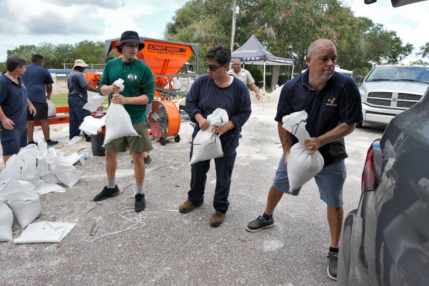 Mitarbeiter der Park- und Freizeitbehörde von Tampa in Florida helfen Anwohnern beim Verladen von Sandsäcken.