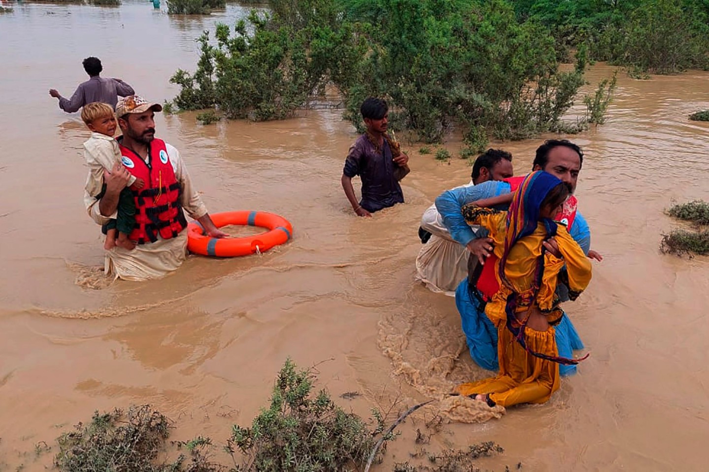Rettungskräfte helfen Dorfbewohnern bei der Evakuierung aus einem durch starke Regenfälle überfluteten Gebiet. Wegen Rekordfluten müssen in der pakistanischen Provinz Belutschistan derze...