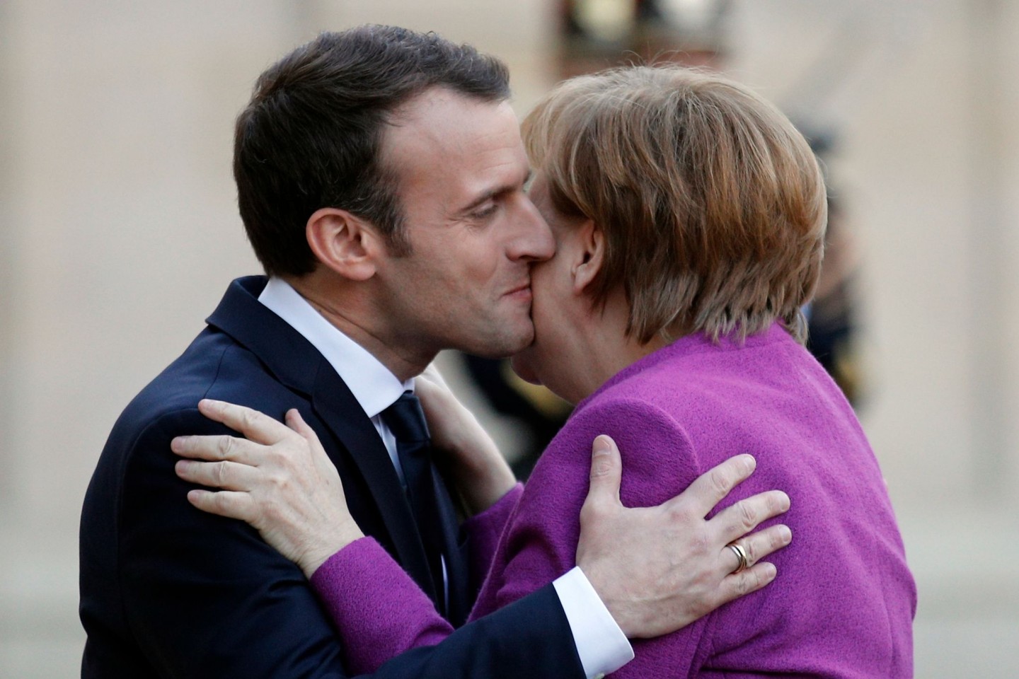 Frankreichs Präsident Emmanuel Macron und Noch-Bundeskanzlerin Angela Merkel geben sich Küsschen.