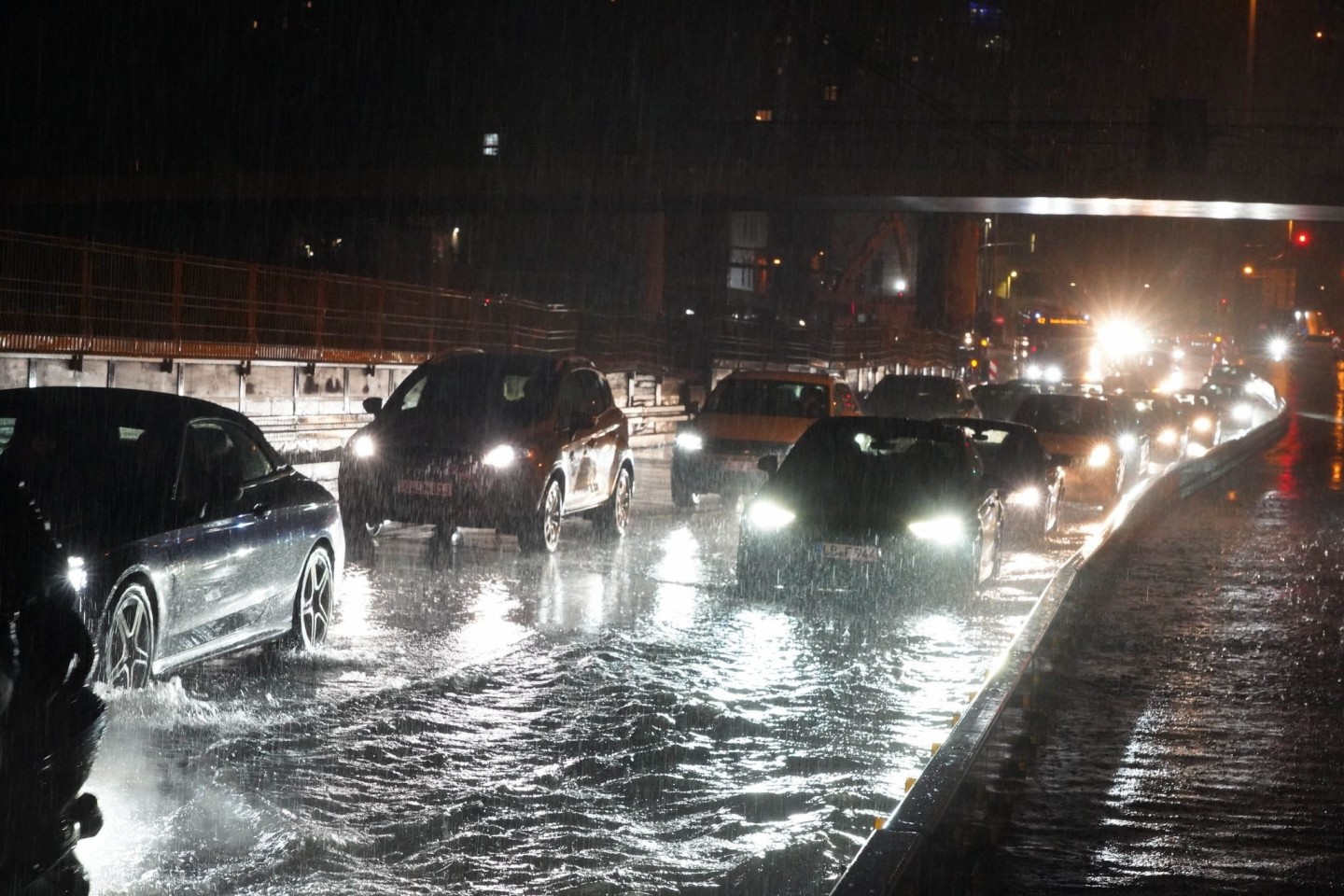 Autos fahren über die überflutete Schillerstrasse am Stuttgarter Hauptbahnhof.