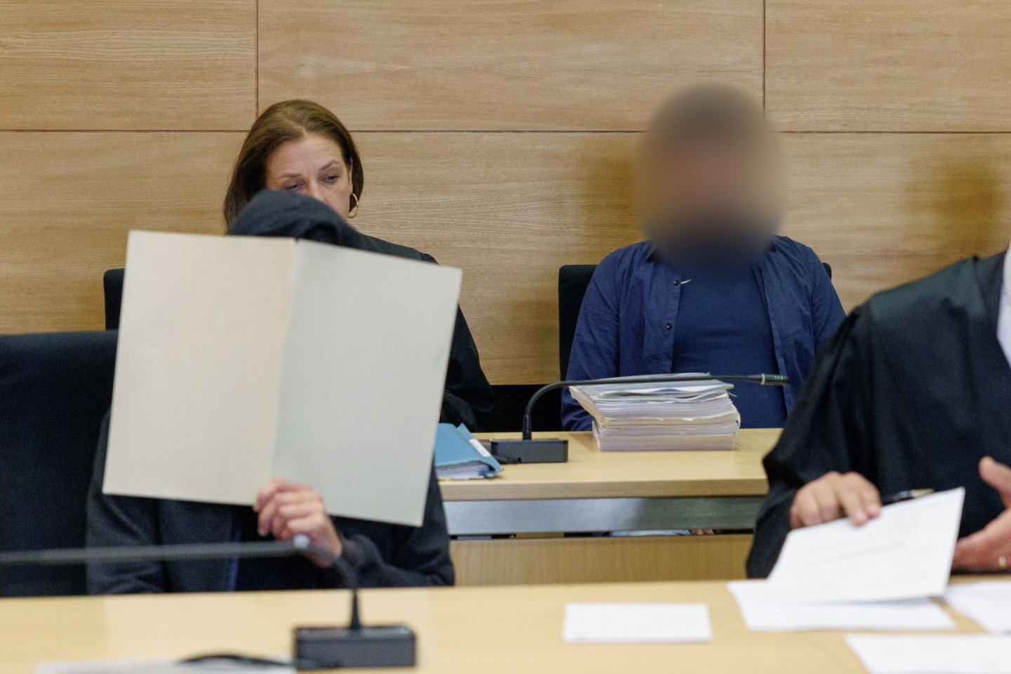 Zwei Angeklagte (vorne l und hinten r) im Gerichtssaal im Landgericht Bielefeld.