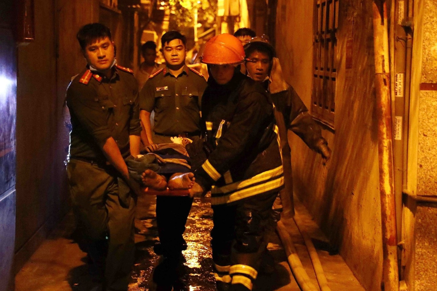 Rettungskräfte tragen eine Person aus einem brennenden Gebäude in der vietnamesischen Hauptstadt Hanoi.