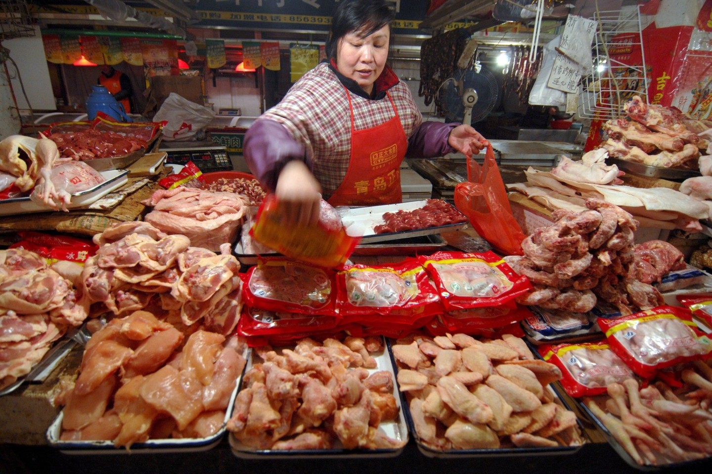 Eine Verkäuferin auf einem Markt in China legt Geflügel aus.