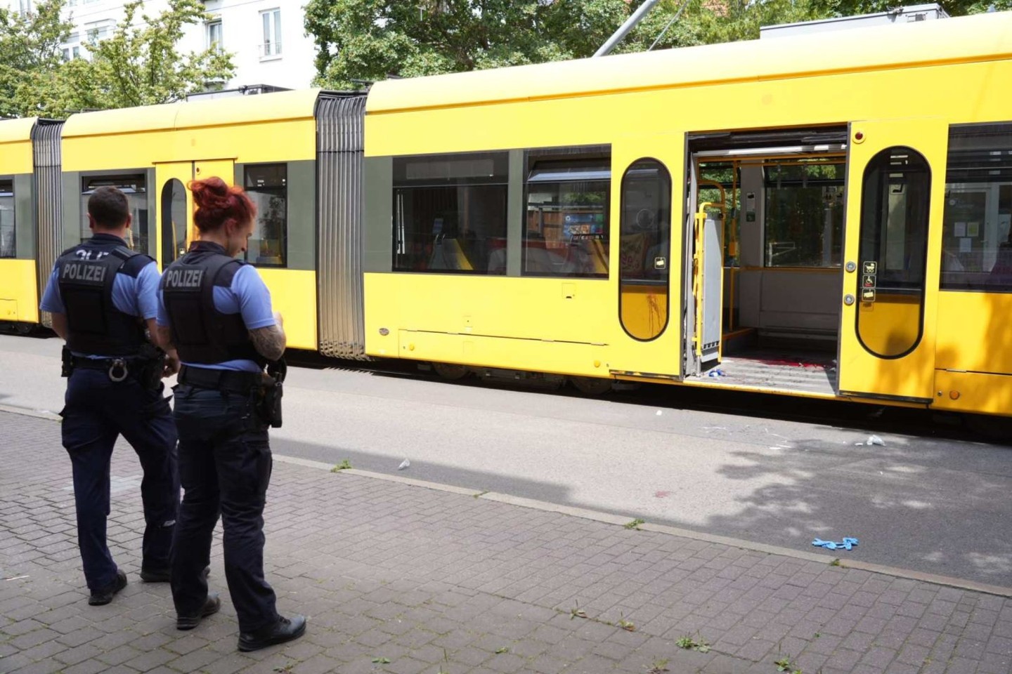 Polizisten stehen in Dresden vor der Straßenbahn, in der es zu der Messerattacke kam.