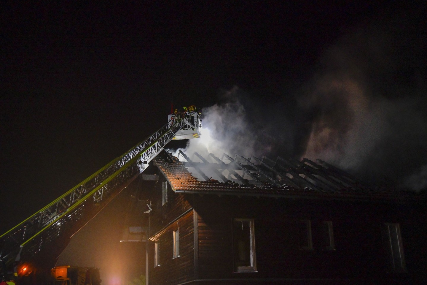 Die Feuerwehr löscht den Brand im Dachstuhl eines Hauses nach einem Blitzeinschlag.