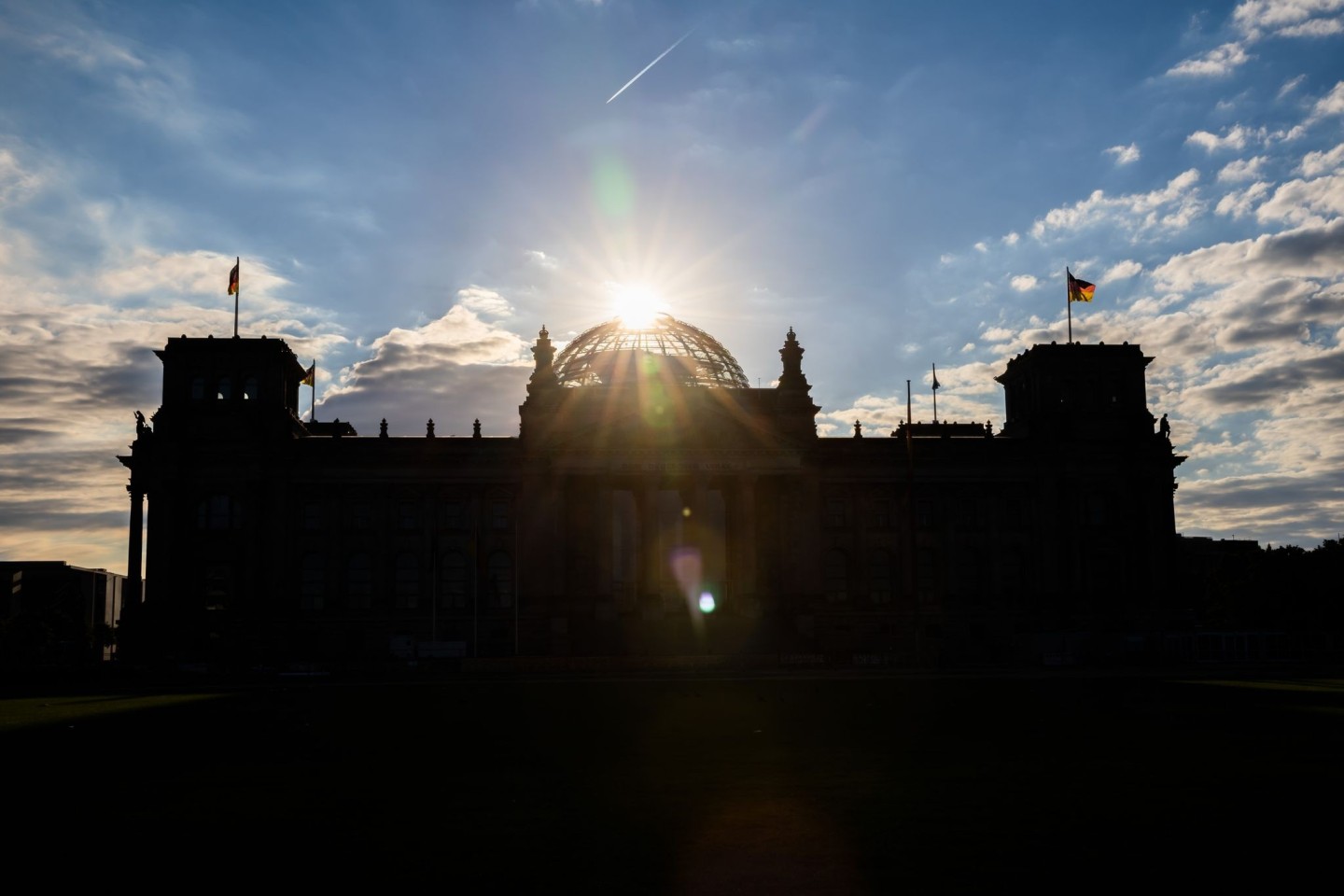 Über dem Reichstagsgebäude geht die Sonne auf.