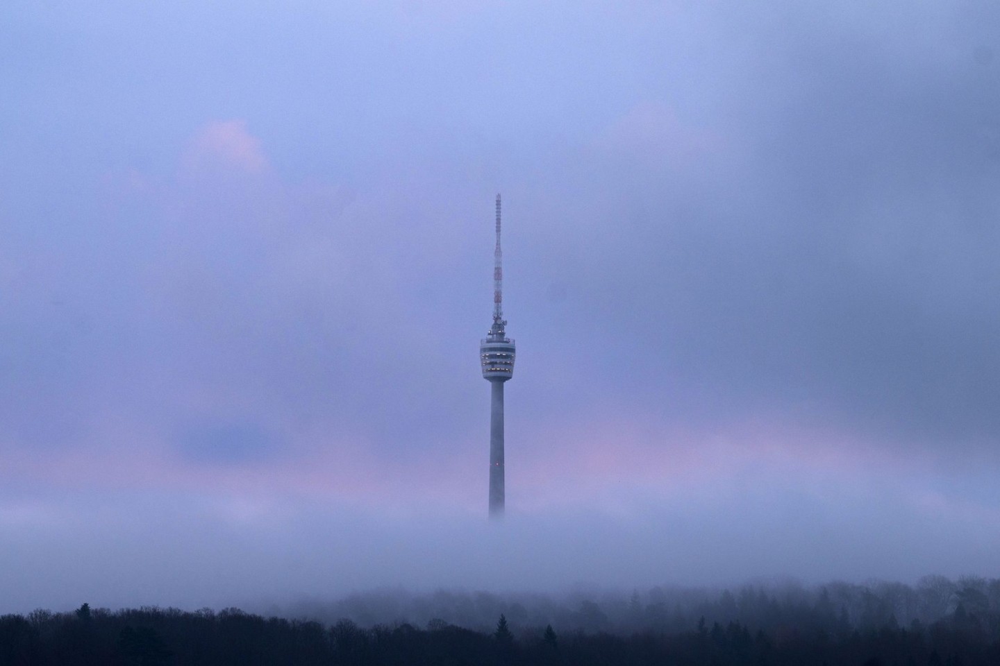 Der Stuttgarter Fernsehturm am frühen Morgen zwischen Wolken.