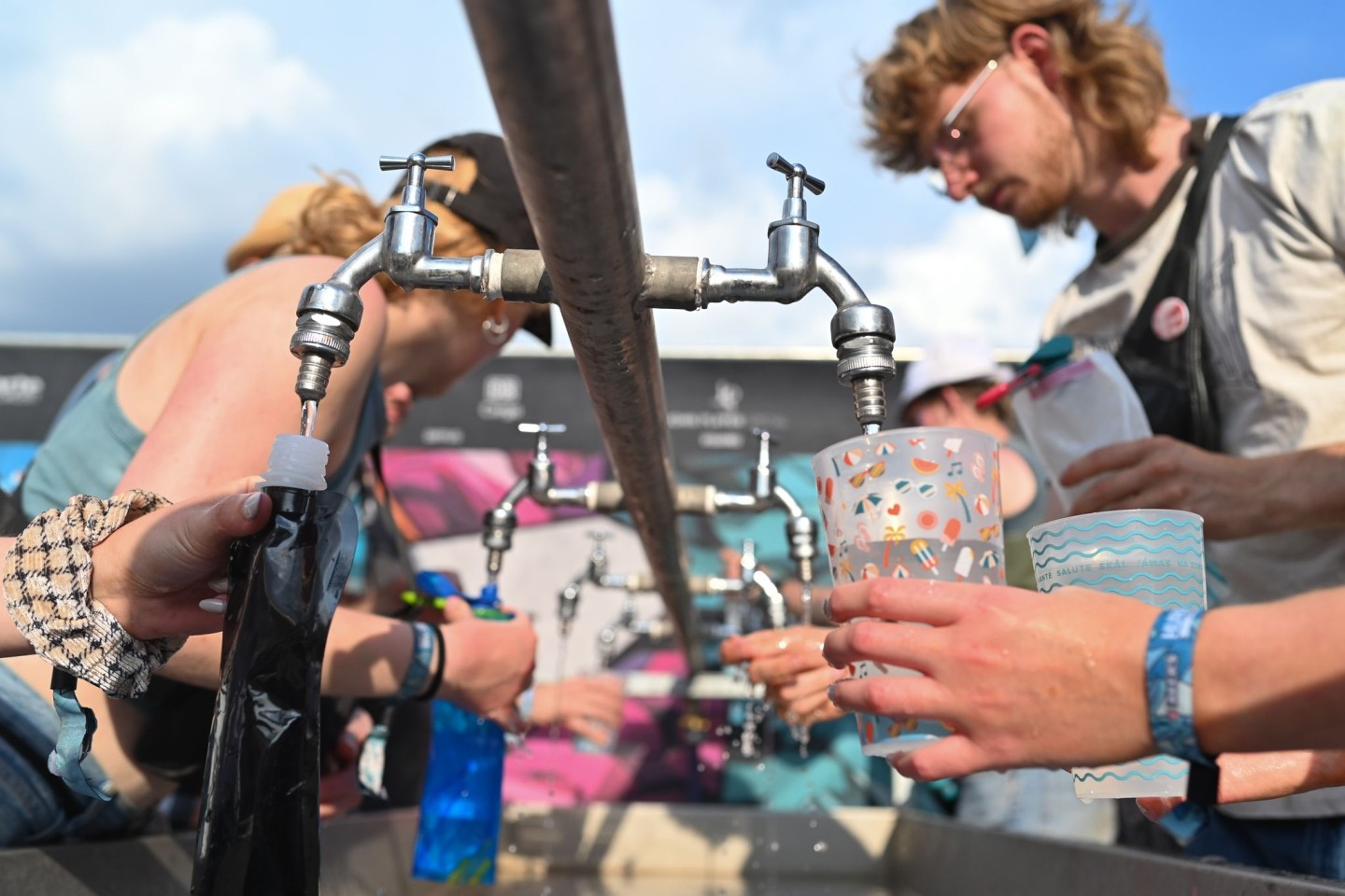 Besucher füllen beim Hurricane Festival ihre Becher und Trinkflaschen mit Wasser auf. In Deutschland steigen die Temperaturen - und die Ozon-Werte.