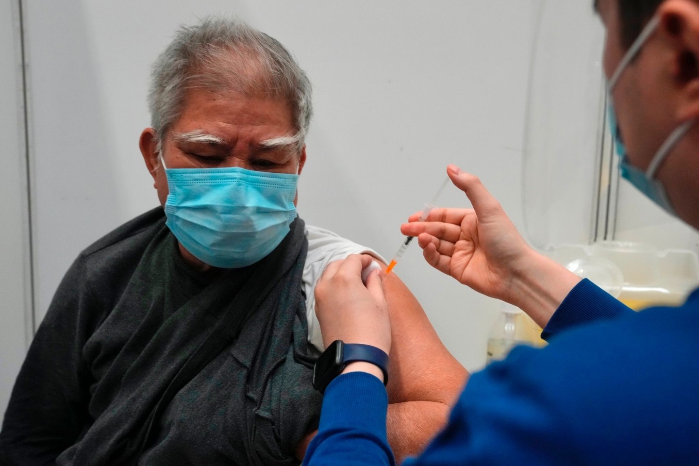 Hui Ngai-seng erhält in einem Impfzentrum in Hongkong seine erste Dosis des chinesischen Corona-Impfstoffs Sinovac.