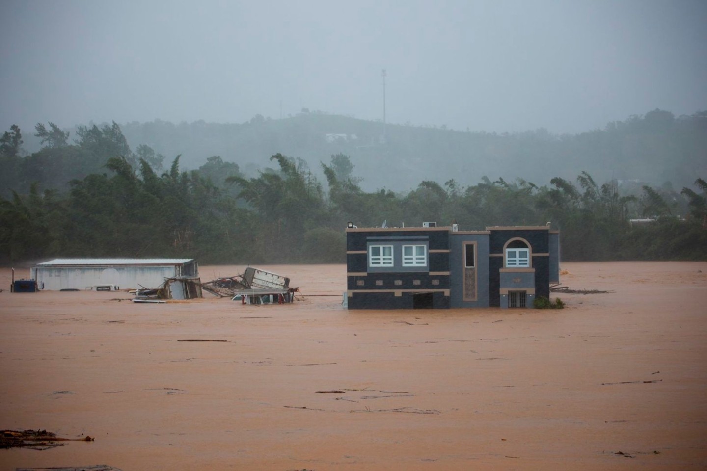Drei Menschen warten in einem Haus auf Rettung vor den Überschwemmungen, die Hurrikan «Fiona» in Puerto Rico verursacht hat.