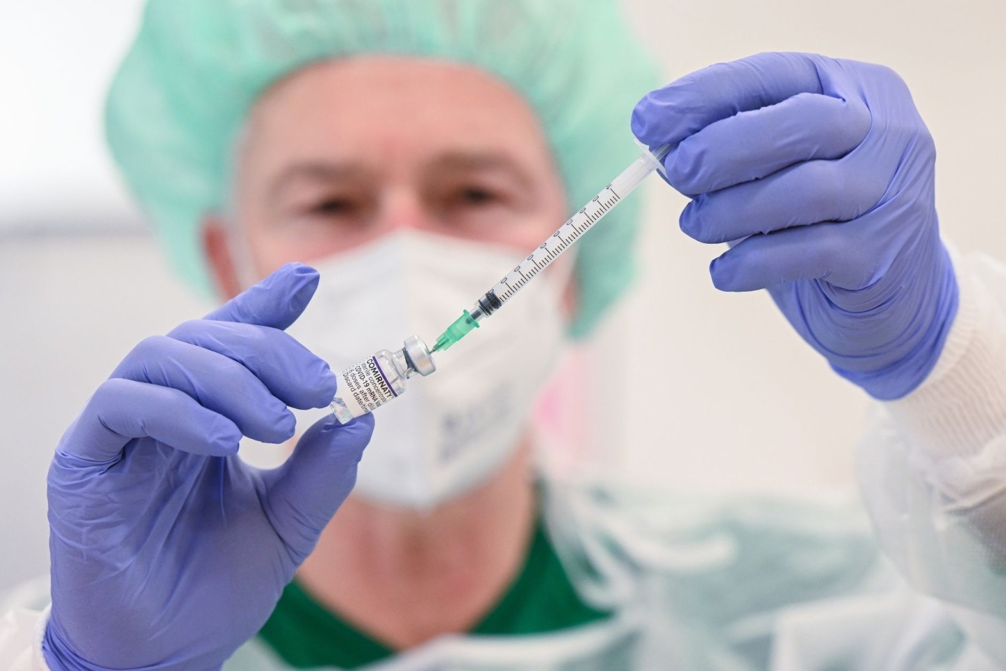 Ein Mitarbeiter des Klinikums Stuttgart bereitet in einer Impfstation eine Spritze für eine Impfung gegen das Coronavirus vor.