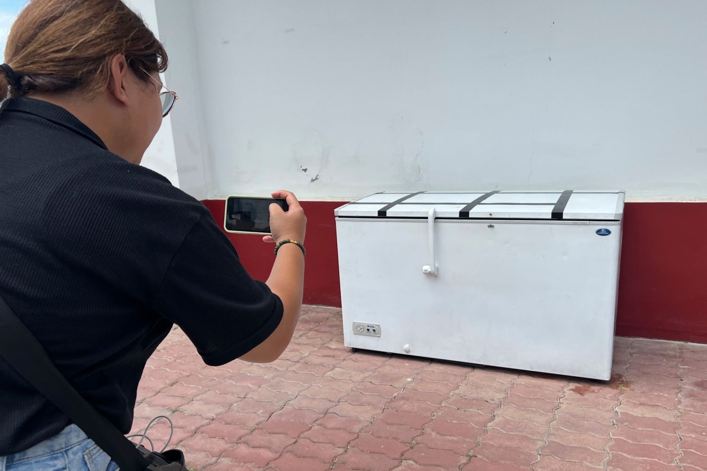 Eine Reporterin macht in einer Polizeistation in Pattaya ein Foto von der Kühltruhe, in der die Leiche von Hans-Peter M. gefunden wurde.
