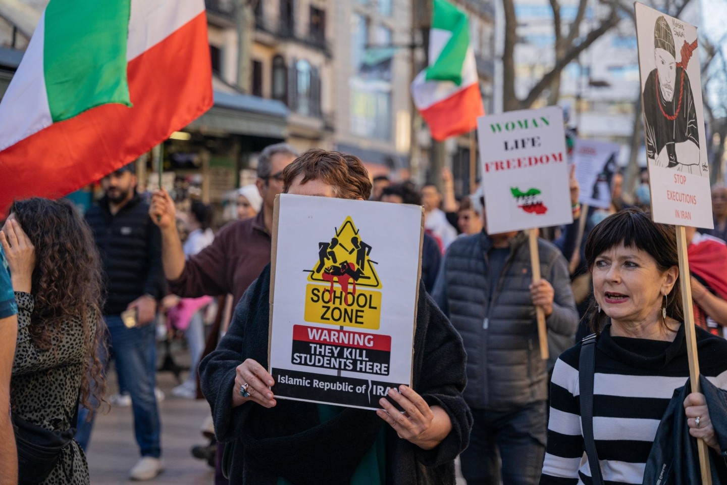 Demonstranten protestieren in Barcelona mit Plakaten und Fahnen gegen eine mutmaßliche Vergiftungswelle in Schulen in Iran.