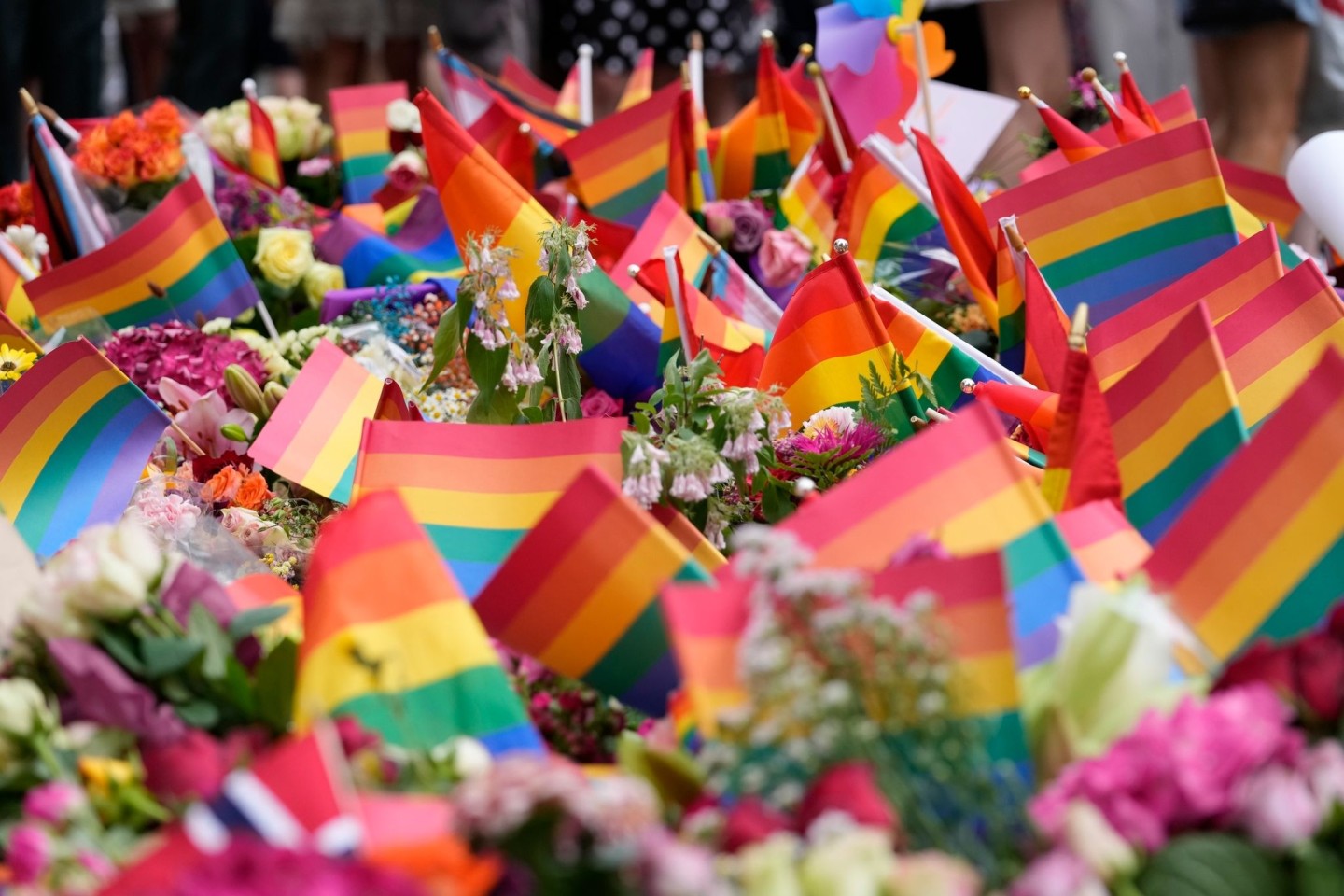 Blumen und Regenbogenfahnen liegen nach den tödlichen Schüssen in einer Schwulen-Bar in Oslo vor dem Tatort.