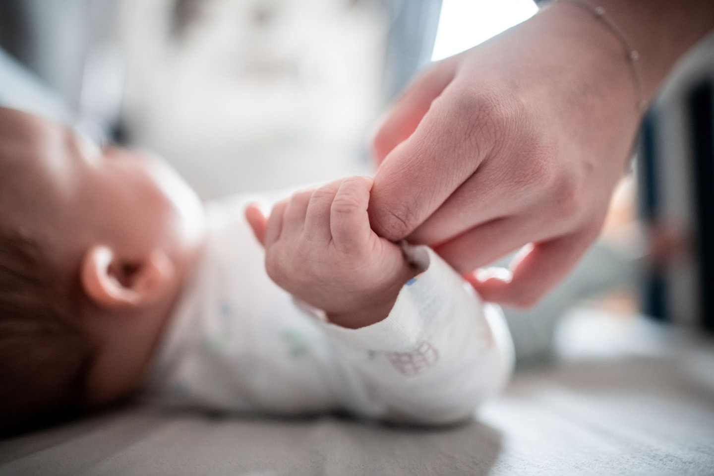 Ein Baby klammert sich an den Finger seiner Mutter. In Italien kommen immer weniger Babys zur Welt.