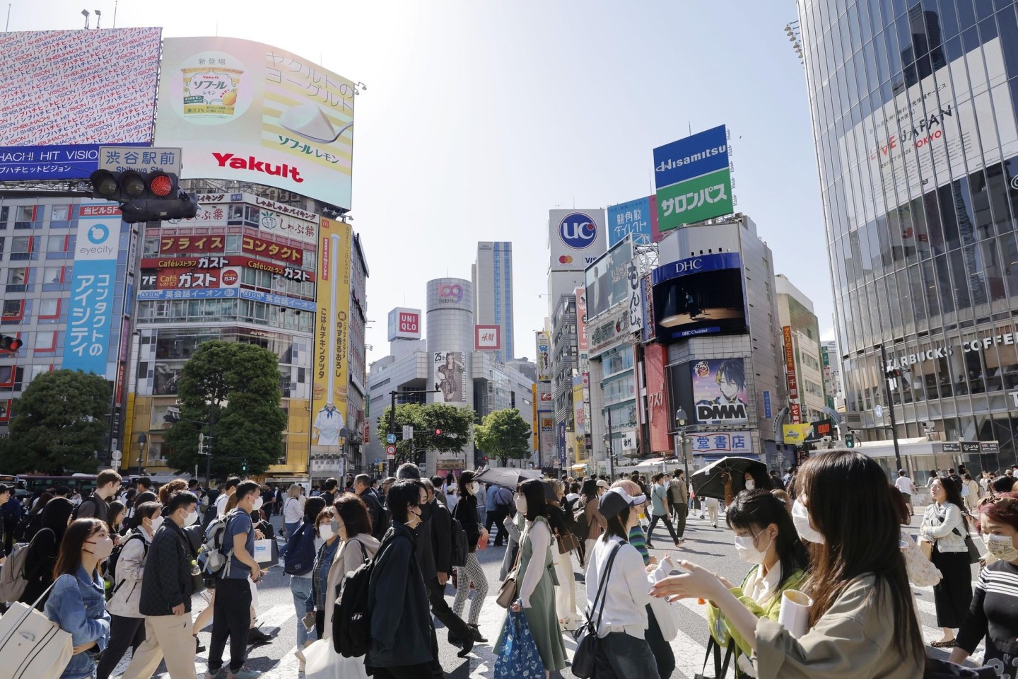 Menschen gehen in Japans Hauptstadt Tokio über eine Kreuzung.