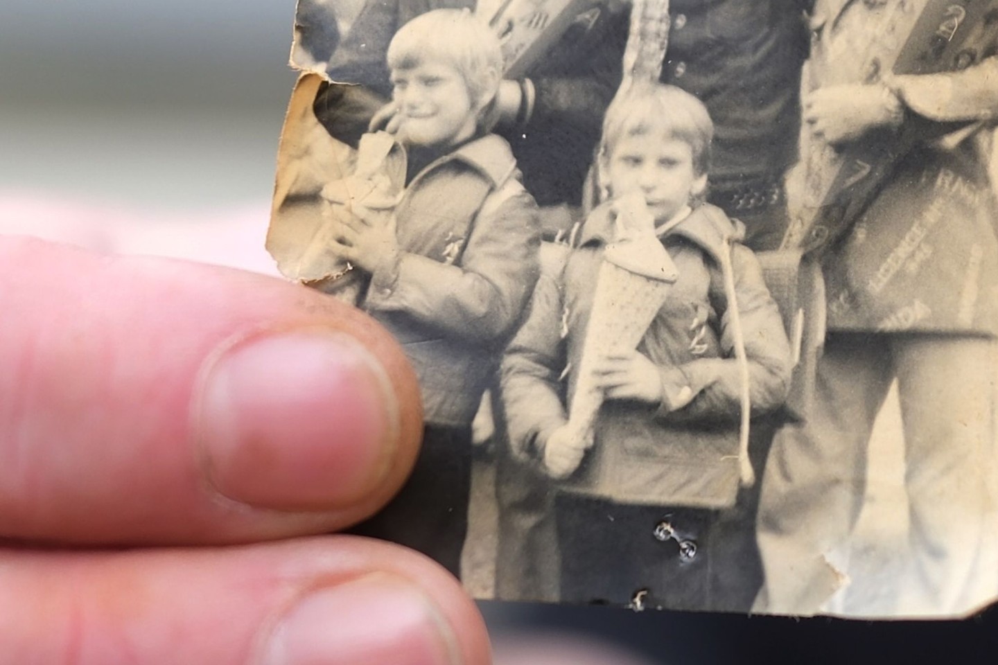 Kai Oppermann, in DDR-Kinderheimen groß geworden, zeigt ein Foto von seiner Einschulung. In der Bildmitte ist er in der vorderen Reihe mit Zuckertüte zu sehen. Links daneben steht sein Bru...