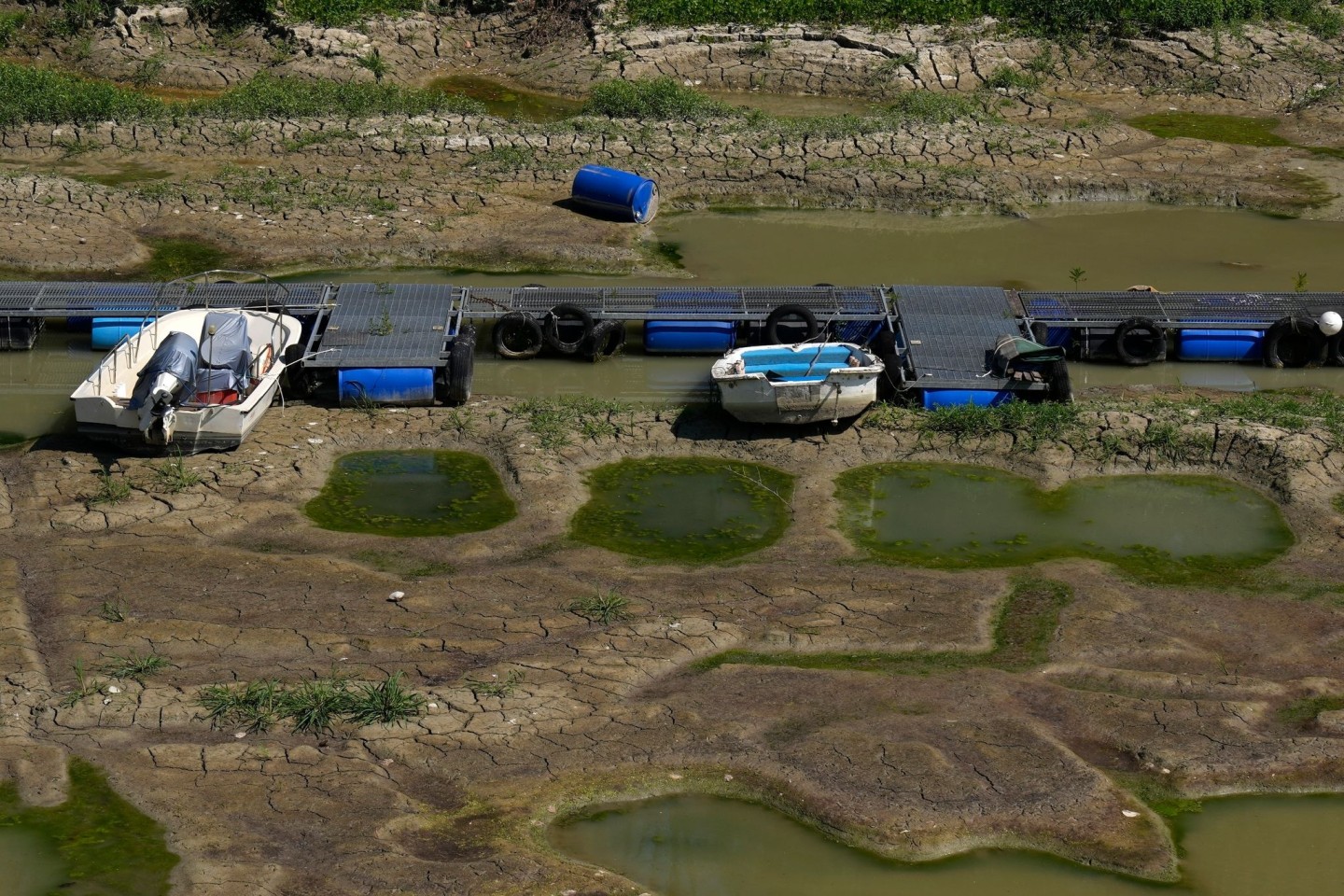 Boote liegen in einem Touristenhafen auf dem ausgetrockneten Flussbett des Pos. Die Dürre in Italien hat die für die Bewässerung wichtigen Flüsse austrocknen lassen.