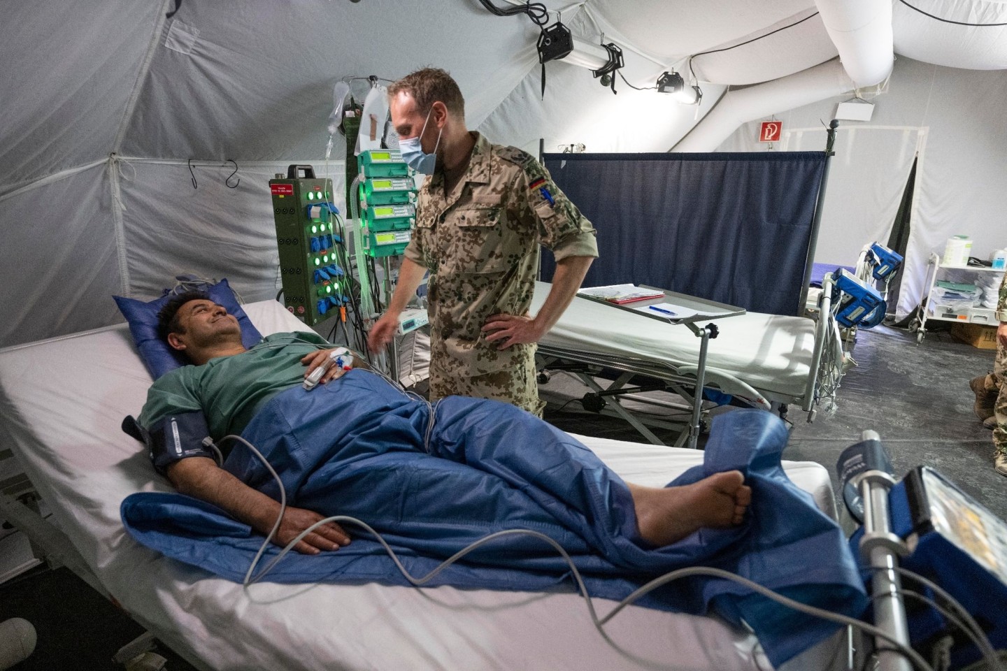 Ein Bundeswehr-Arzt kümmert sich im mobilen Feldkrankenhaus der Bundeswehr um einen Patienten.