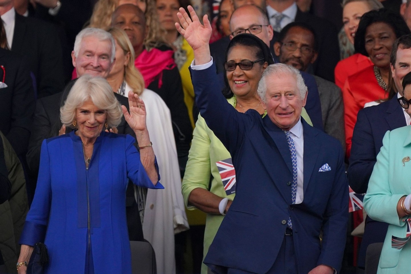 Der britische König Charles III. und Königin Camilla winken während des Konzerts auf Schloss Windsor.