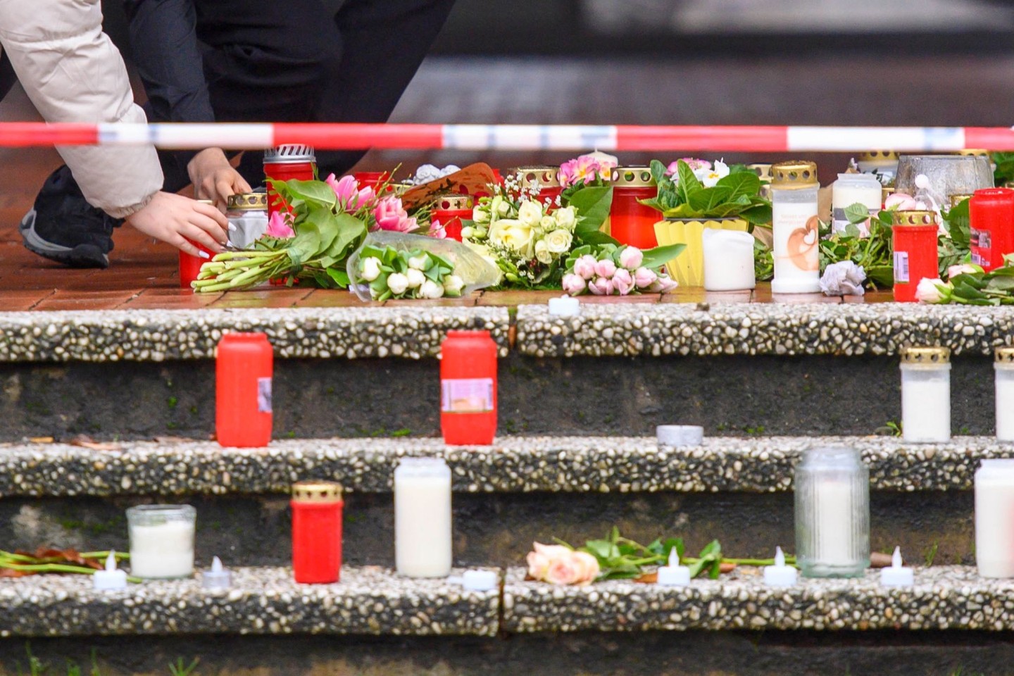 Auf einer Treppe vor dem Berufskolleg Tecklenburger Land in Ibbenbüren legen Schüler Kerzen und Blumen für die getötete Lehrerin ab.