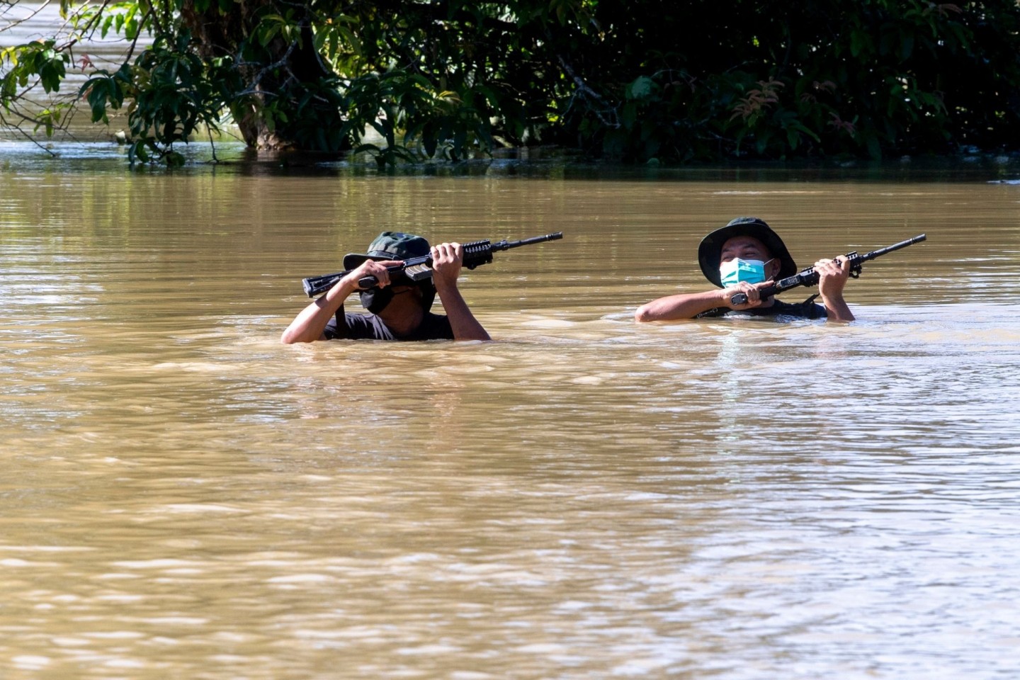 Zwei Soldaten waten durch eine überflutete Straße.