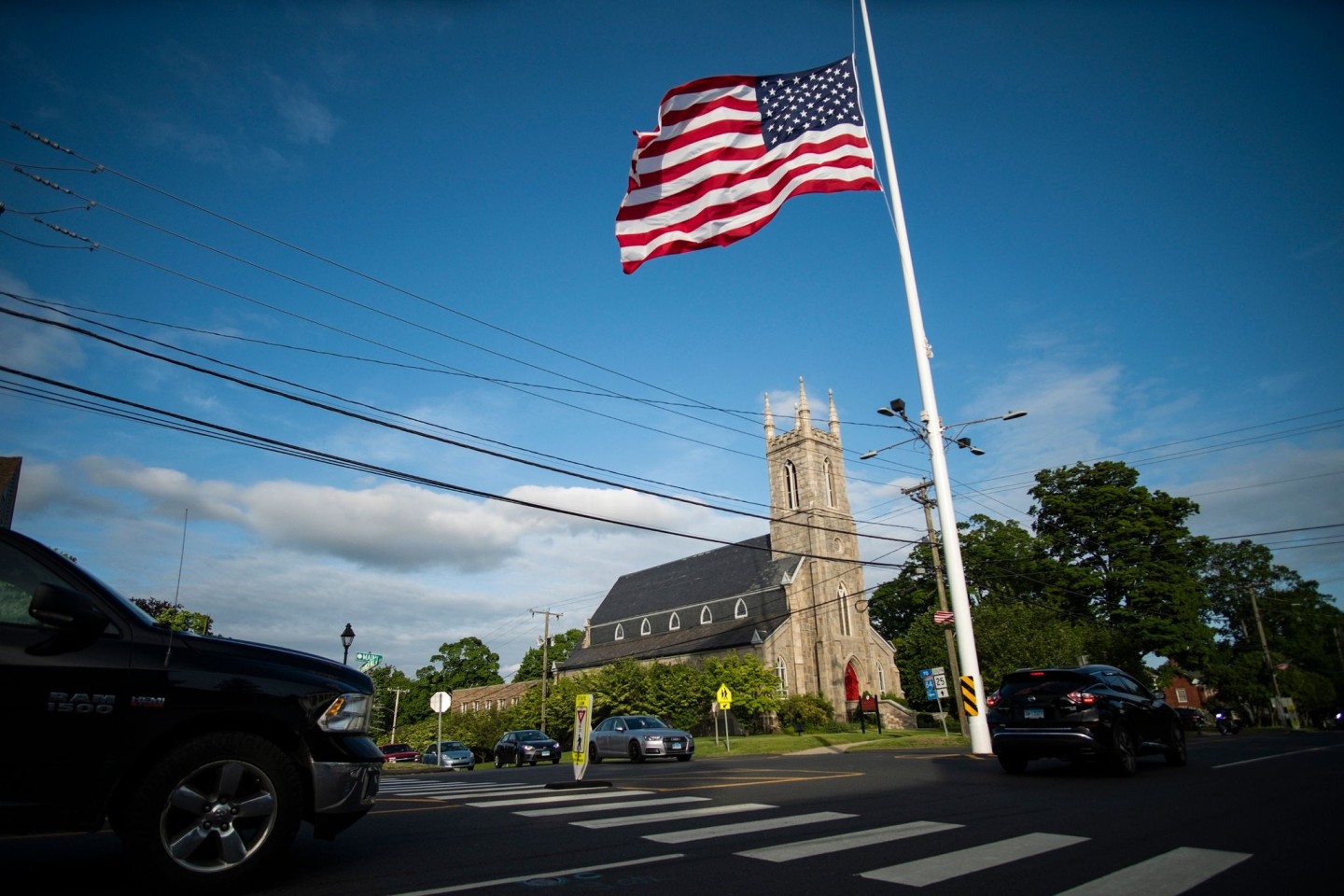 US-Flagge auf halbmast vor einer Kirche, in der eine Mahnwache aus Solidarität mit den Familien von Uvalde stattfindet.