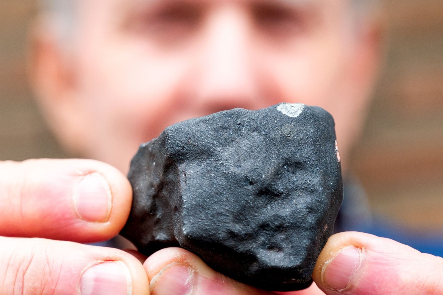 Hausbesitzer Wilfried Labusch mit einem kleinen Meteoriten, der niedergegangen ist.