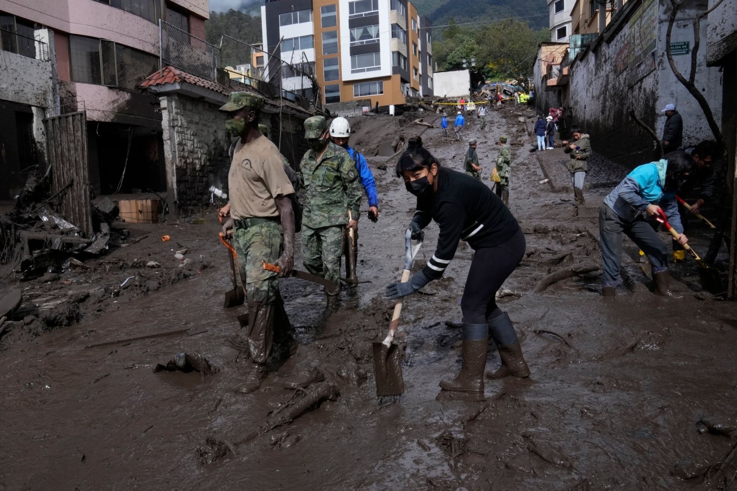 Anwohner und Soldaten arbeiten daran, die Straßen in der Hauptstadt Quito von Schlamm zu befreien.