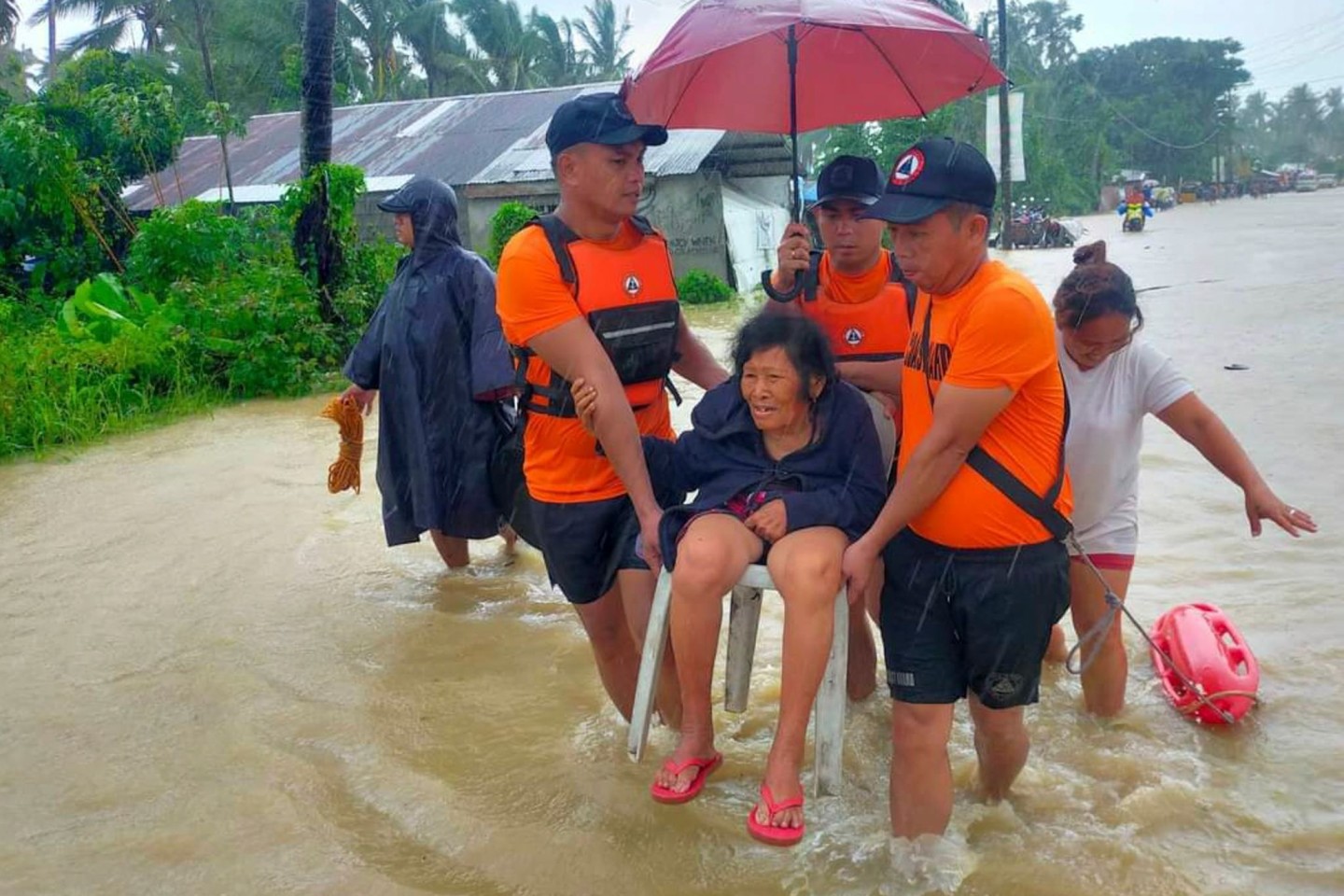 Rettungskräfte evakuieren Bewohner aus einem überschwemmten Gebiet auf den Philippinen.
