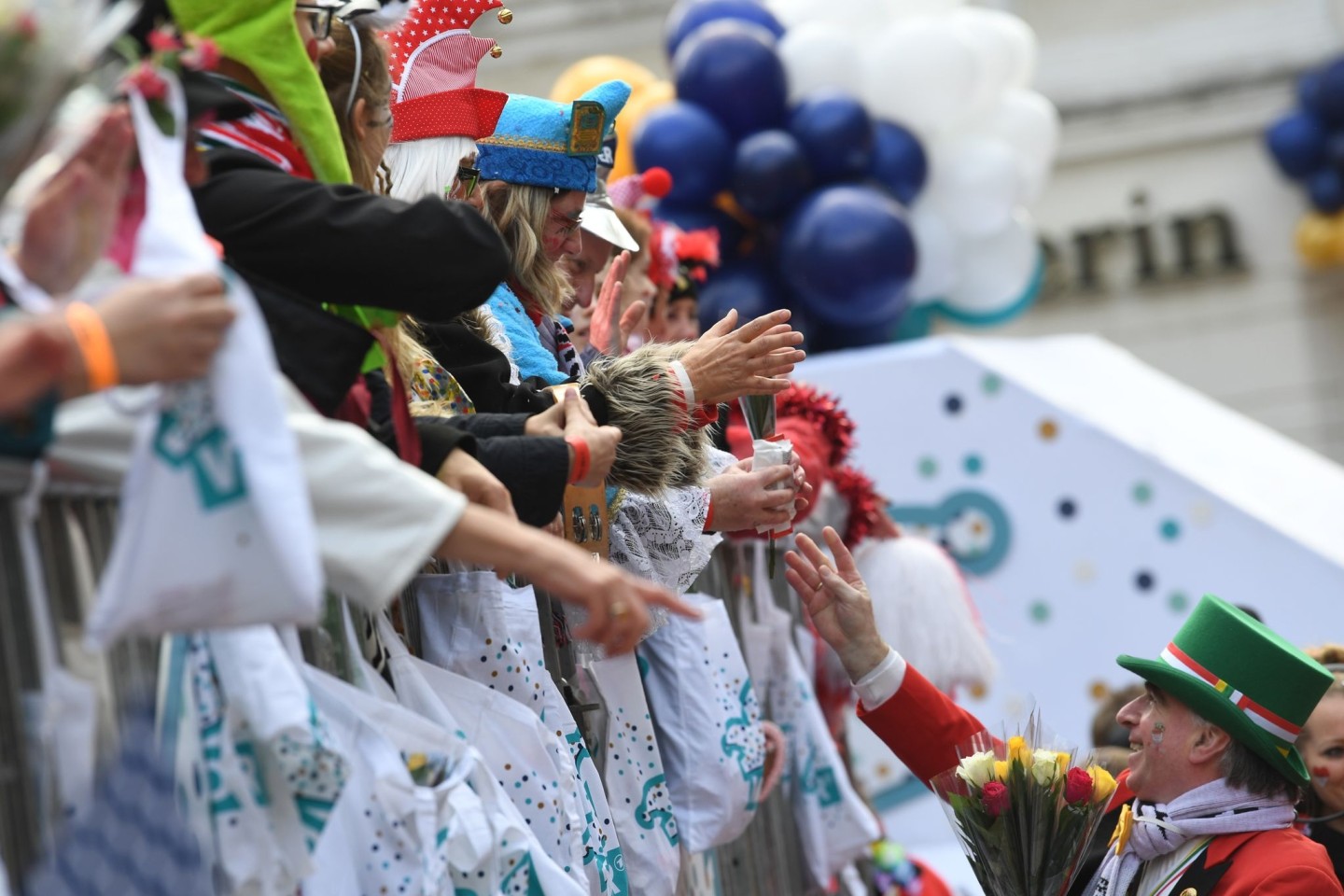 Karnevalisten auf dem Wagen verteilen beim Kölner Rosenmontagszug Kamelle und Blumensträuße (Strüßjer) - doch wie umweltfreundlich sind eigentlich die Verpackungen?