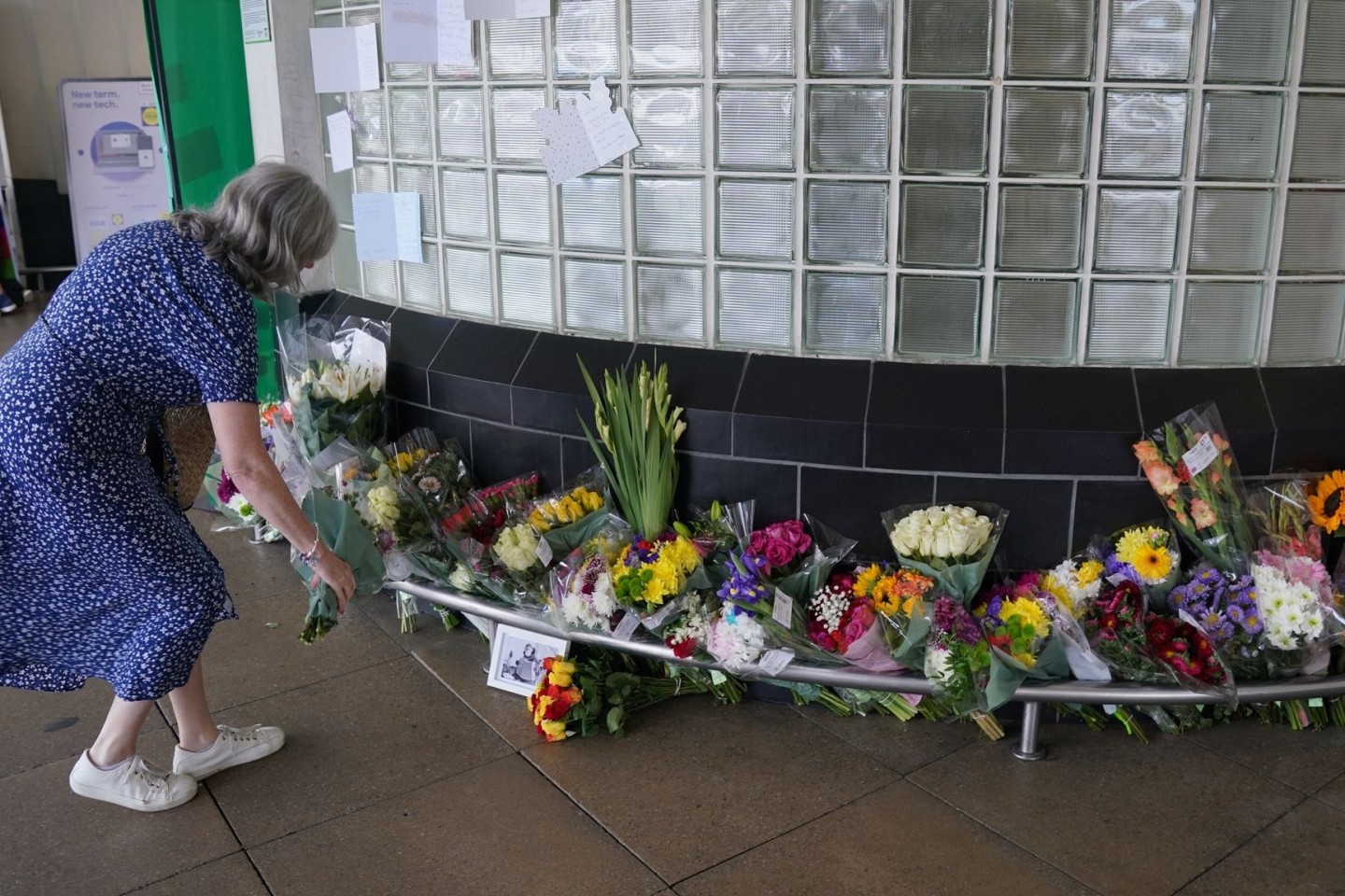 Eine Frau legt Blumen vor dem Perivale Tesco in London ab, wo der 87-jährige Thomas O'Halloran erstochen wurde.
