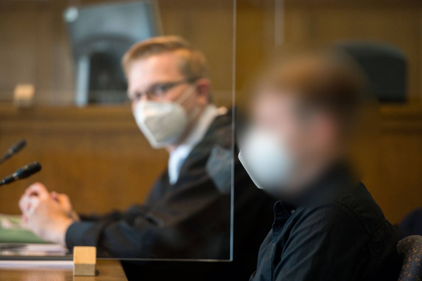Der Angeklagte und sein Anwalt (l) sitzen im Gerichtssaal des Landgerichts Saarbrücken.