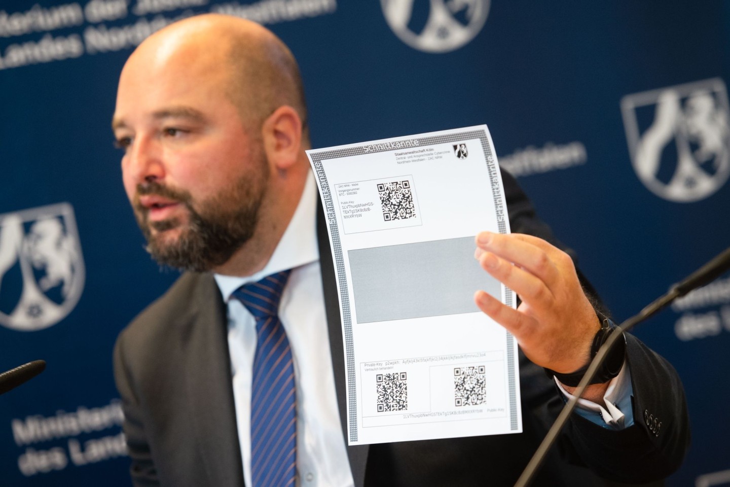Andreas Brück, Staatsanwalt bei der Zentral- und Ansprechstelle Cybercrime (ZAC NRW), mit einem Paper Wallet für Bitcoin.