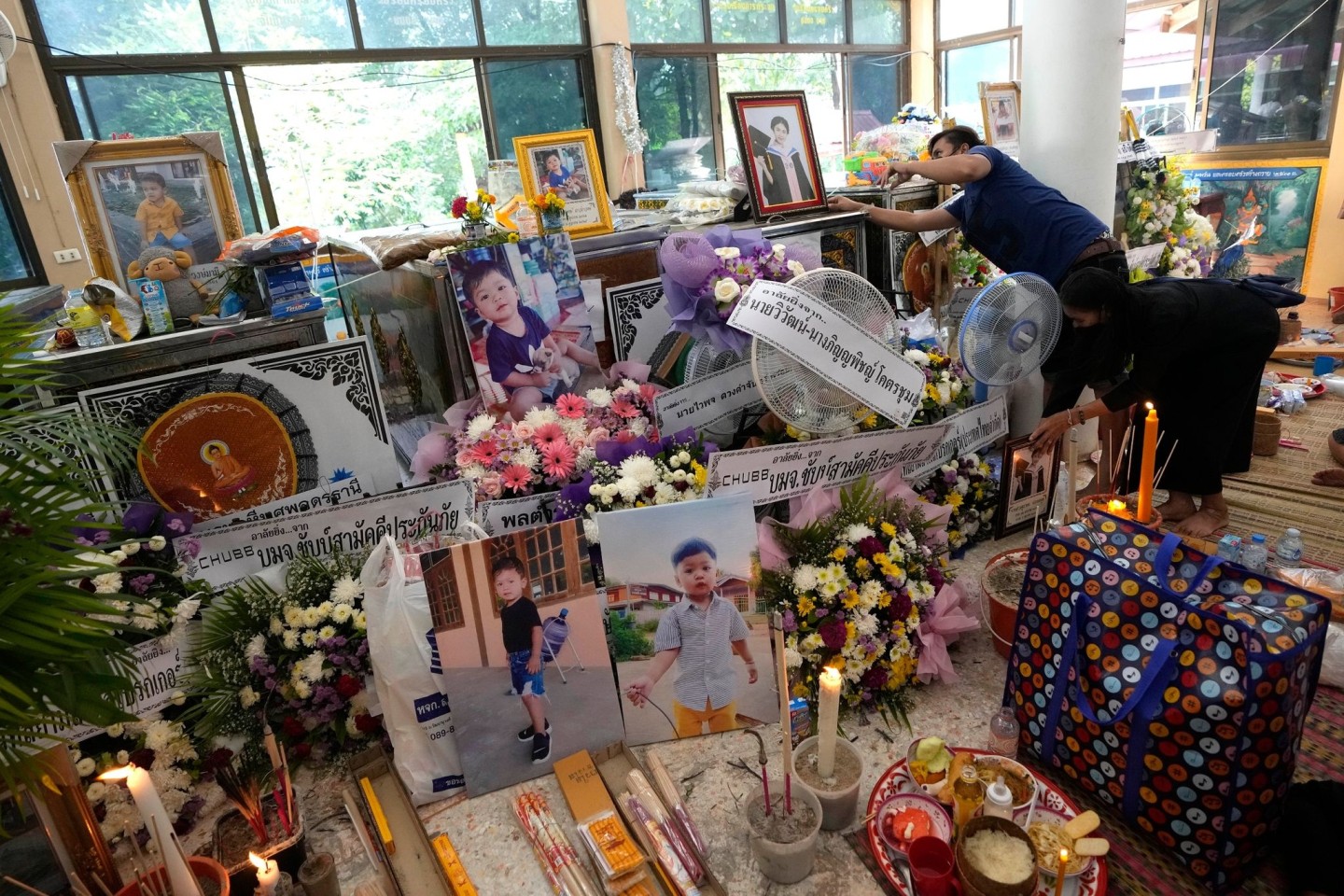Angehörige der Opfer des Kita-Attentats sammeln Bilder und Andenken vor einer buddhistischen Zeremonie in der Stadt Uthai Sawan im Nordosten Thailands.