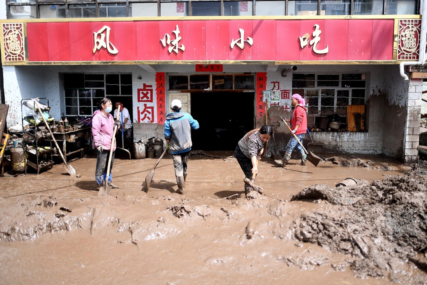 Anwohner entfernen Schlamm von ihrem Grundstück in der nordwestchinesischen Provinz Qinghai.