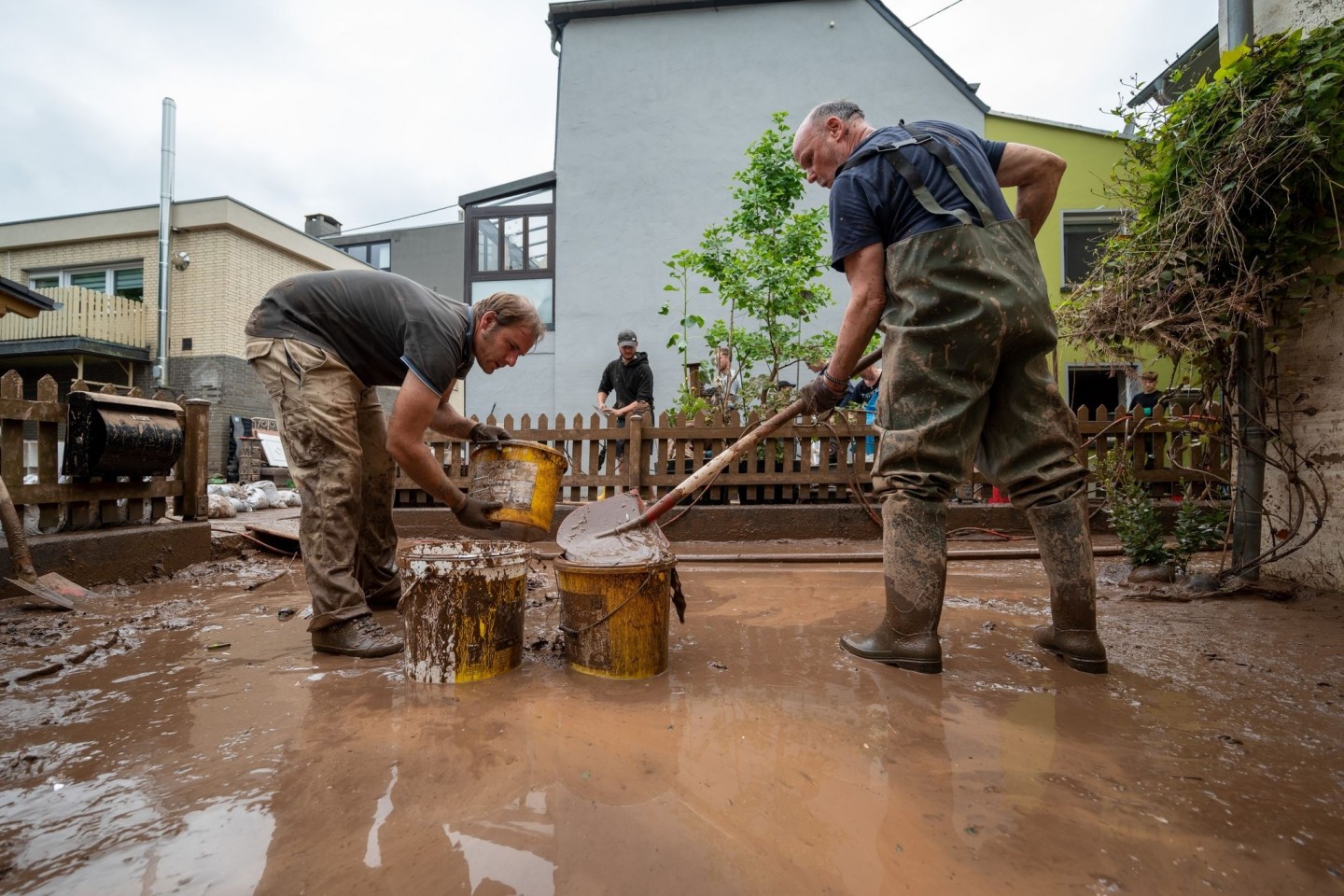 Mit Eimern entsorgen Anwohner die Schlammmassen nach dem Hochwasser der Kyll. Zahlreiche Häuser im Ort waren betroffen, Bewohner mussten evakuiert werden.