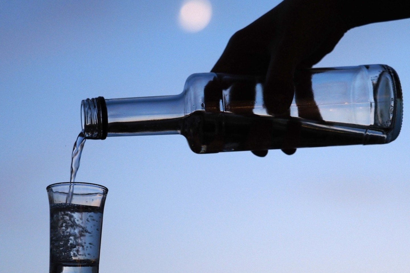 Ein Mann gießt hochprozentigen Alkohol in ein Glas. (Symbolbild)